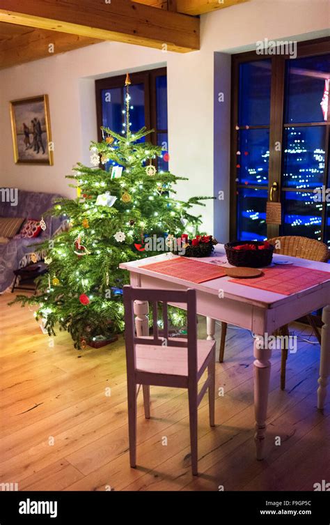 Living room with decorated Christmas tree and white wooden dining table Stock Photo - Alamy