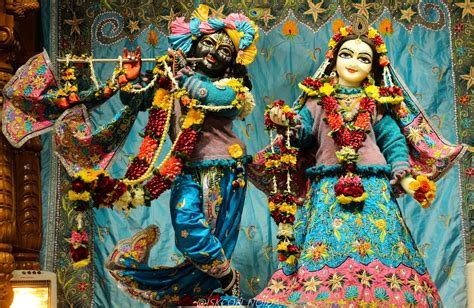 two colorfully dressed statues in front of a blue backdrop