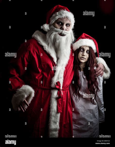 portrait of a scary looking santa claus and an elf Stock Photo - Alamy