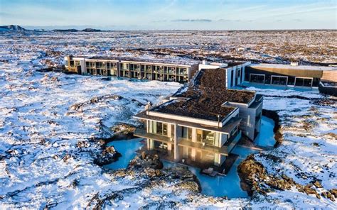 an aerial view of a building in the middle of nowhere with snow on the ground