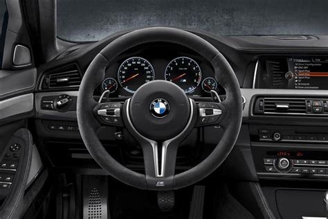 the interior of a bmw car with black leather trims and gauges, steering ...