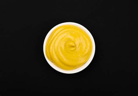 Premium Photo | White bowl of yellow American mustard on table