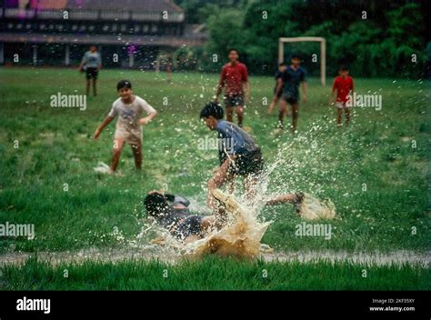 Boys playing football soccer in rain Mumbai Stock Photo - Alamy