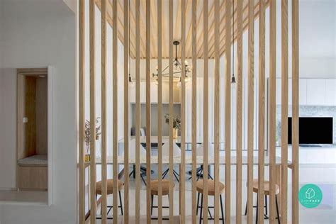 a room divider with wooden slats on the wall and chairs in front of it