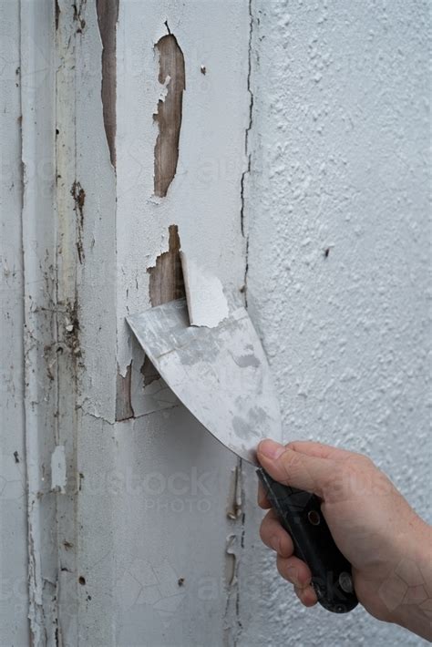 Image of Scraping old paint from window frame - Austockphoto