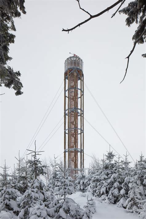 a lookout tower rises above the forested mountains of a czech ski area