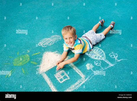 Little boy drawing chalk image on the ground Stock Photo - Alamy