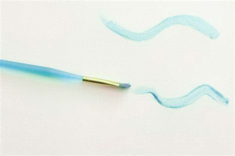 Free Stock Photo 12147 Paintbrush with Blue Wavy Lines on White Paper | freeimageslive