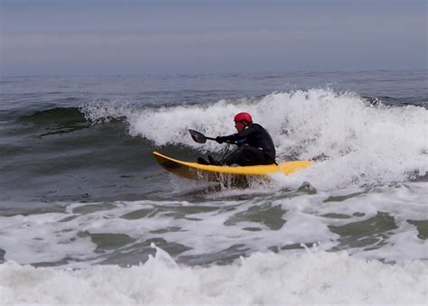 a man riding on top of a yellow surfboard in the ocean