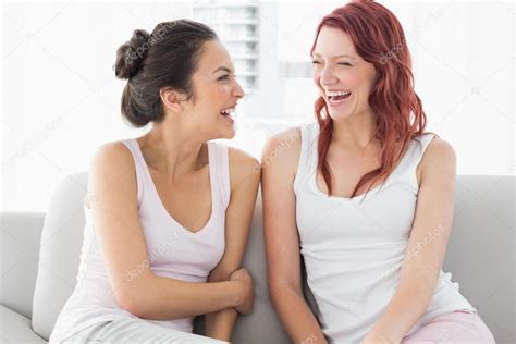 Beautiful female friends laughing in the living room — Stock Photo © lightwavemedia #37826239