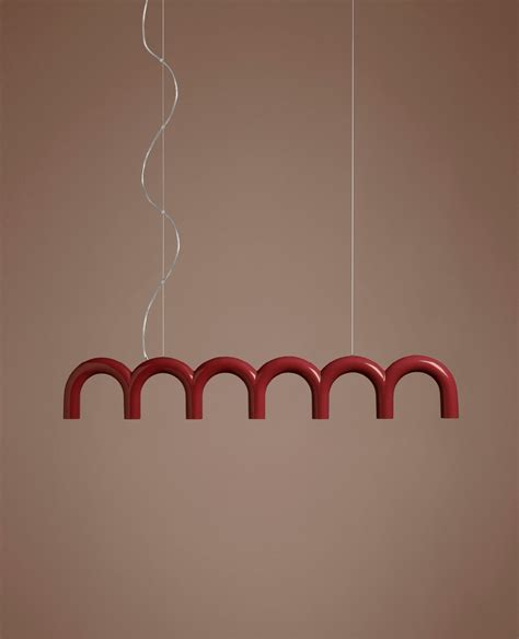 a red light hanging from the ceiling in front of a brown wall with white lines