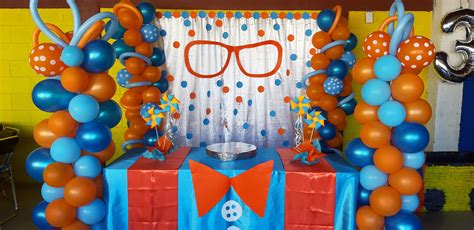 an orange and blue balloon arch with glasses on it