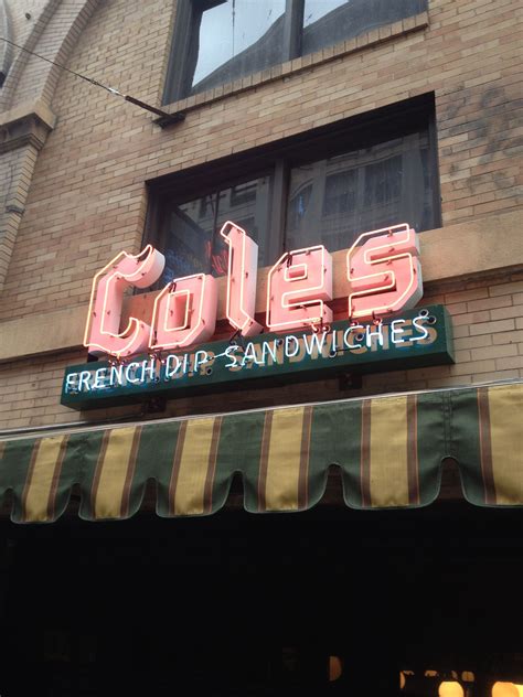 the neon sign for cole's french pizz and sandwiches is lit up outside