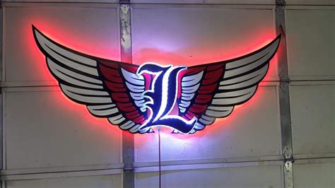 a neon sign with wings on the side of a building