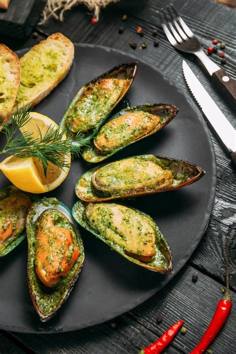 Closeup on Delicious Cooked Mussels with Sauce, Lemon and Garlic Bread Stock Photo - Image of ...