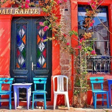 colorful chairs and tables in front of a red building with stained ...