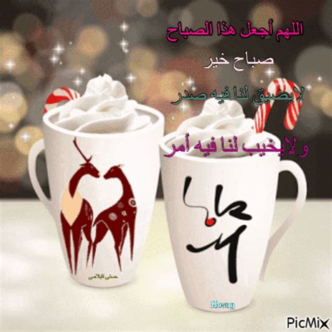 two white coffee mugs filled with whipped cream and candy canes on top of a table