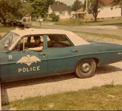 an old police car is parked on the side of the road