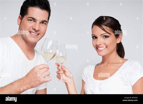 Couple toasting with white wine glasses Stock Photo - Alamy