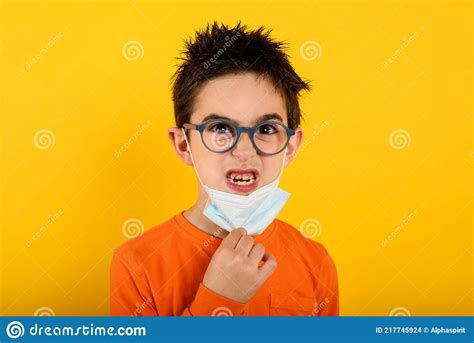 Portrait of a Angry Child that Want Remove Face Mask for Covid-19 Coronavirus. Yellow Background ...
