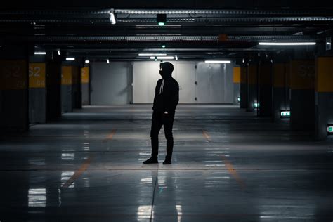 Man in Black Hoodie and Pants Standing on Gray Concrete Floor of a Carpark · Free Stock Photo