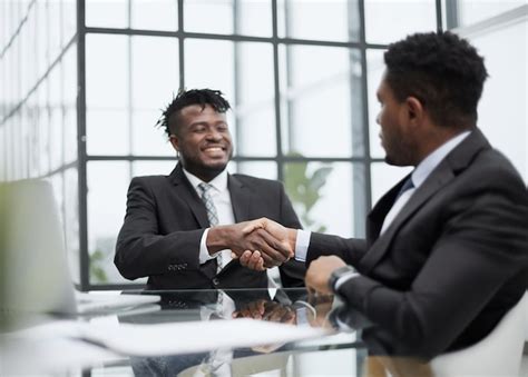 Premium Photo | Shot of two young business men shaking hands in a modern office