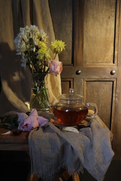 Premium Photo | A glass teapot with a bunch of flowers in it