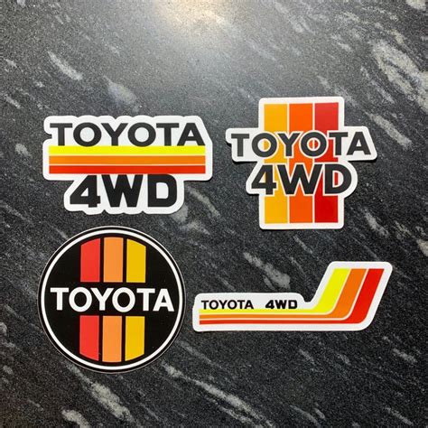 the toyota 4wd stickers are on top of a black marble surface with white and yellow stripes