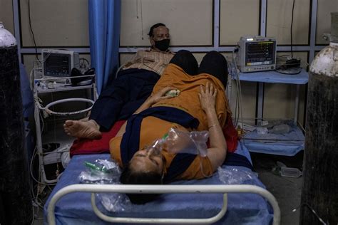 Two to a bed in Delhi hospital as India's COVID crisis spirals | Reuters