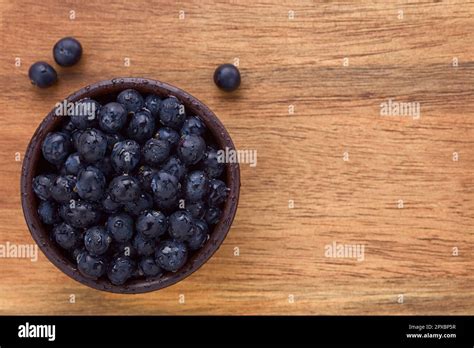 Fresh raw Patagonian Calafate berries (lat. Berberis heterophylla) in rustic bowl, photographed ...