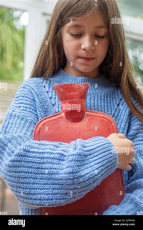 little girl holding hot water bottle against her Stock Photo - Alamy