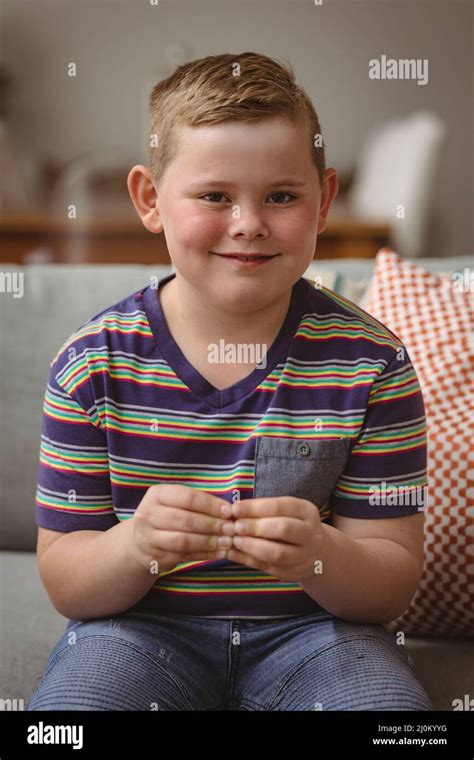 Portrait of caucasian boy making hand gestures sitting on the couch at home Stock Photo - Alamy