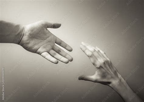 Giving a helping hand. Hand reaching out to help another. Stock Photo | Adobe Stock