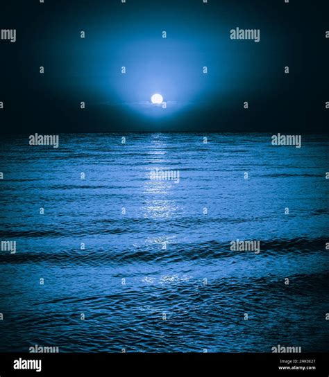 Moon reflecting in a lake sea ocean waves. Moonlight night background Stock Photo - Alamy