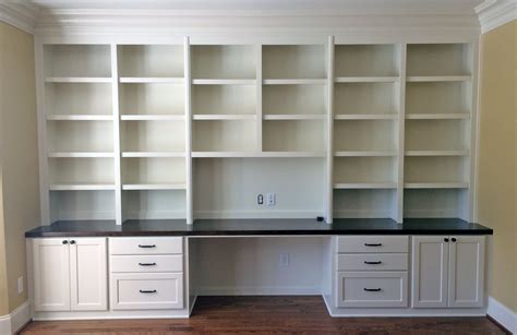 Custom built-in desk with shaker style doors and drawers, adjustable shelves, stained wooden ...