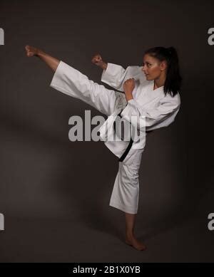 Woman in white kimono kicks high in the air - a karate martial art girl ...