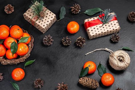 Christmas gifts with tangerines and cones on a black background. The view from the top (Flip ...