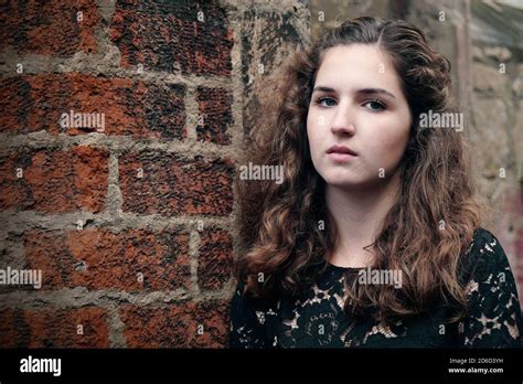 young woman leaning against old brick wall with copyspace Stock Photo - Alamy