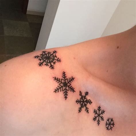 snowflakes on the back of a woman's shoulder and chest are shown