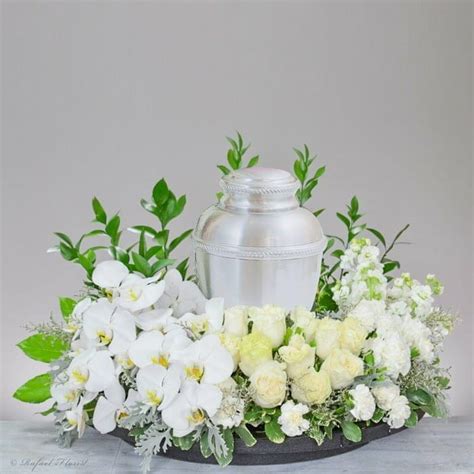 A serene floral design of all white gorgeous blooms for cremation service.