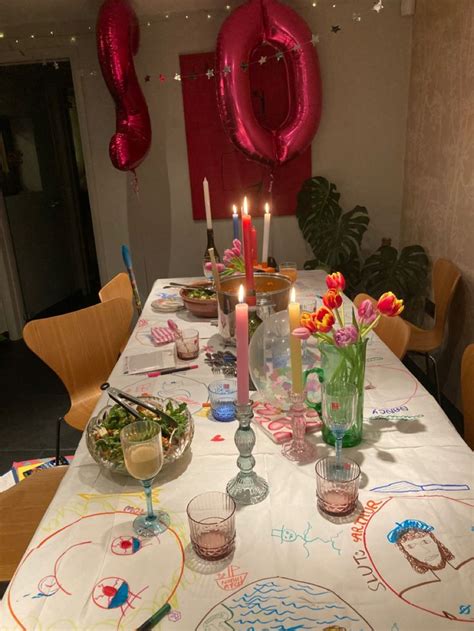 the table is set for a birthday party with candles and flowers in vases on it