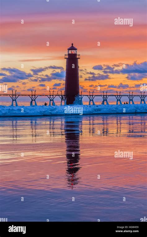 Grand Haven Lighthouse at sunset, at the mouth of the Grand River where ...