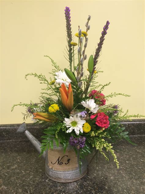 a bouquet of flowers in a watering can