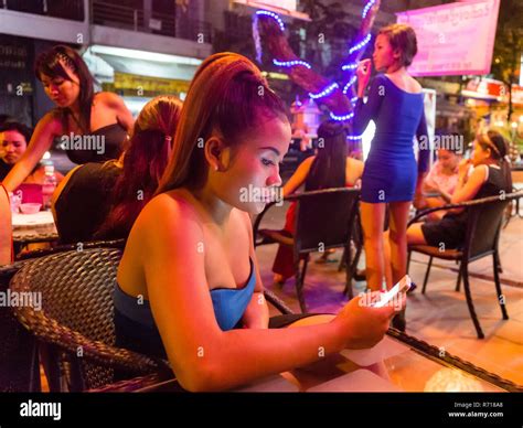 Nightlife, barmaid holding smartphone, clubs, Phnom Penh, Cambodia ...