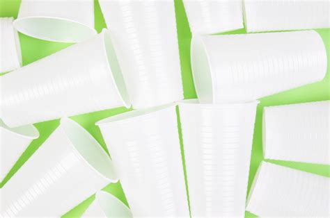 White plastic cups on green background - Creative Commons Bilder