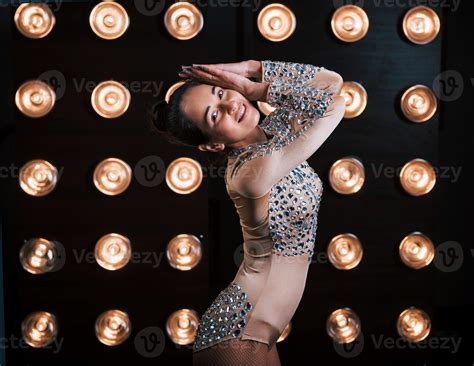 Beautiful female assistant of magician posing in the studio with lights ...