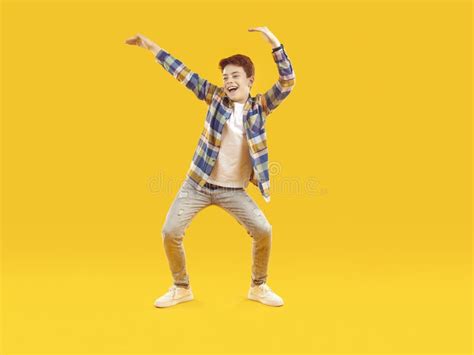 Funny, Cheerful Child in Casual Clothes Dancing Against a Yellow Studio ...