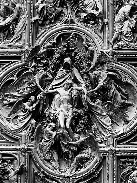 an ornate sculpture on the side of a building with angels and other people around it