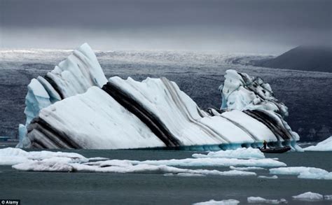 Icebergs as you've never seen them before: Incredible pictures of giant glaciers with black ...