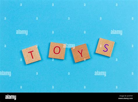 The word TOYS, spelt with wooden letter tiles over blue background. Top ...